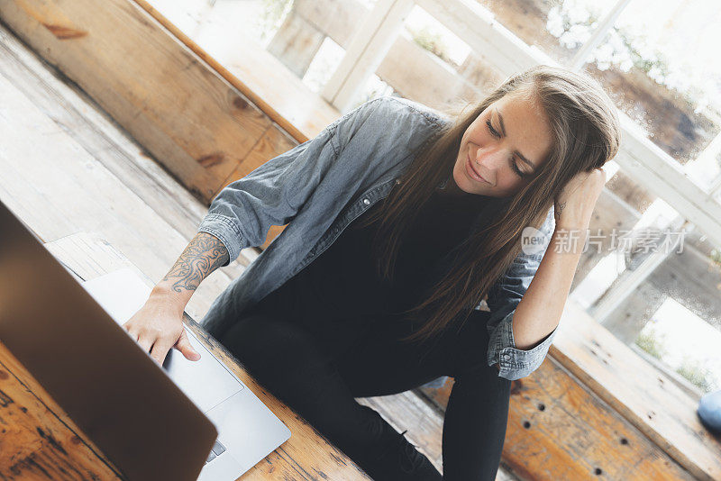 Young female working with laptop on a rustic café